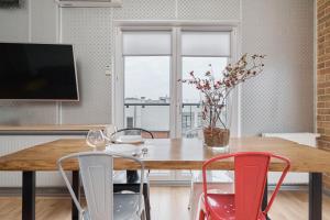 een eetkamer met een tafel met stoelen en een televisie bij Beautiful Apartment with Spacious Balcony by Renters in Wrocław
