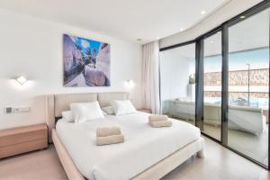 a white bedroom with a large bed and glass windows at Infinity 0-2 LUXE PARTIAL SEA VIEW 2B in Arona +12 photos