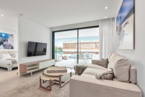 a living room with a couch and a tv at Infinity 0-2 LUXE PARTIAL SEA VIEW 2B in Arona