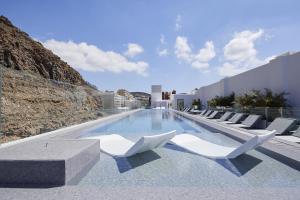 a swimming pool with white lounge chairs on a building at Infinity 0-2 LUXE PARTIAL SEA VIEW 2B in Arona