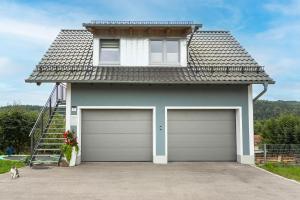 a house with two garage doors in front of it at Ferienwohnung Knecht in Georgenberg