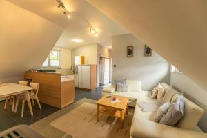 a living room with a couch and a table and a kitchen at Ferienwohnung Knecht in Georgenberg