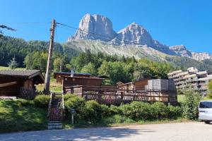 a building with a mountain in the background at Chez K&D Au Col De l'Arzelier in Château-Bernard