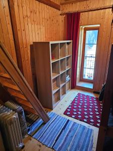 a room with a staircase and a book shelf and a window at L'ancien hospice in Bourg-Saint-Pierre