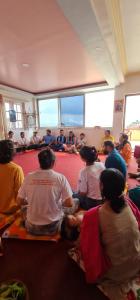 um grupo de pessoas sentadas no chão em uma sala em Budhanilkantha em Burhānilkantha