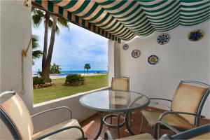 a table and chairs on a balcony with a view of the ocean at Playa Lucera in Sitio de Calahonda