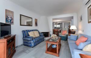 a living room with blue couches and a tv at Playa Lucera in Sitio de Calahonda