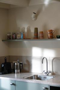 a kitchen with a sink and a counter top at Melkmeisje in Oudeschild