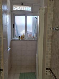 een badkamer met een douche, een raam en een wastafel bij Home Ciampino in Ciampino