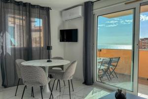 een eetkamer met een tafel en stoelen en een balkon bij Villa Caterina, Proche Monaco et imprenable vu mer in Beausoleil