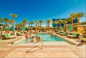 a group of people in a swimming pool at a resort at No Resort Fee - Balcony Strip Views, Pools & Parking in Las Vegas