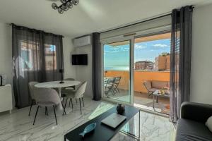 een woonkamer met een tafel en uitzicht op de oceaan bij Villa Caterina, Proche Monaco et imprenable vu mer in Beausoleil