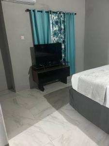 a bedroom with a bed and a television on a table at Oak Villa MontegoBay2 Queen Room in Montego Bay