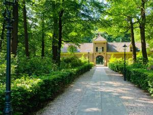 a pathway leading to a yellow house in a park at Hotel Landgoed Zonheuvel in Doorn
