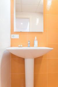 ein Badezimmer mit einem weißen Waschbecken und einem Spiegel in der Unterkunft Casa flamenca a los pies de la Alcazaba in Almería