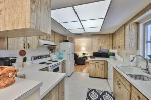 a kitchen with white appliances and wooden cabinets at Lazy Manatee Pool Home in Bradenton