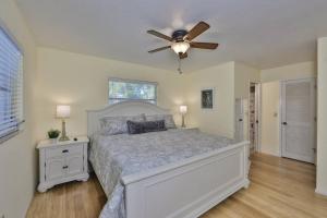 a bedroom with a bed and a ceiling fan at Lazy Manatee Pool Home in Bradenton +33 photos
