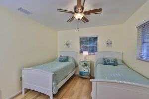 a bedroom with two beds and a ceiling fan at Lazy Manatee Pool Home in Bradenton