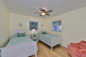 a bedroom with two beds and a ceiling fan at Lazy Manatee Pool Home in Bradenton
