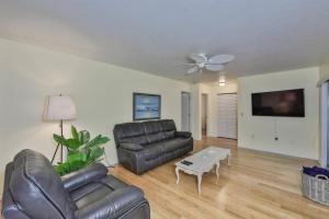 a living room with a leather couch and a table at Lazy Manatee Pool Home in Bradenton