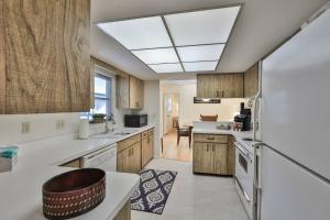 a kitchen with wooden cabinets and a white refrigerator at Lazy Manatee Pool Home in Bradenton