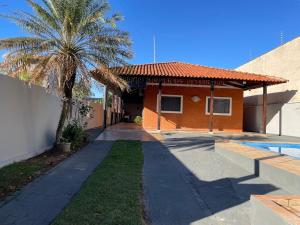a house with a palm tree next to a driveway at Rancho próximo rio pesca Sales in Sales