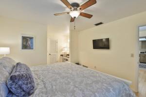 a bedroom with a bed and a ceiling fan at Lazy Manatee Pool Home in Bradenton