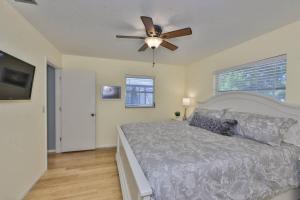 a bedroom with a bed and a ceiling fan at Lazy Manatee Pool Home in Bradenton