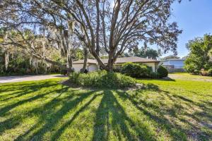 a house with a tree in the yard at Lazy Manatee Pool Home in Bradenton