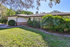 a house with a lawn in front of it at Lazy Manatee Pool Home in Bradenton