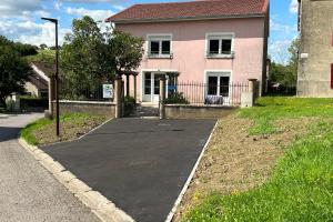a driveway in front of a pink house at Appartement RDC in Remoncourt