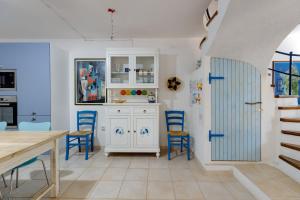 a kitchen with blue chairs and a table at Villetta Lucia a due passi dal mare in Putzu Idu