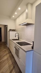 a white kitchen with a sink and a stove at Attico vista mare mozzafiato in Porto Santo Stefano