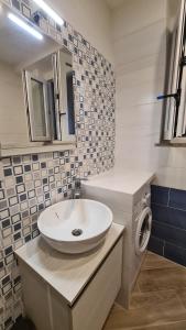 a bathroom with a sink and a washing machine at Attico vista mare mozzafiato in Porto Santo Stefano +2 photos