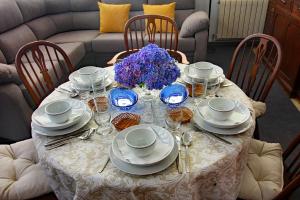 una mesa con platos y vasos y un jarrón de flores en LA CASA ALTA en la ruta del Camino de Santiago, en A Guarda 49 fotos más