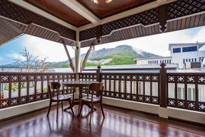 a balcony with a table and chairs and a view at The Color Kata in Kata Beach
