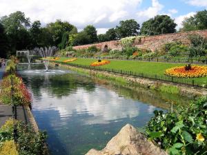 a large pond in a garden with a fountain at *RC9bC* For your most relaxed & Cosy stay + Free Parking + Free Fast WiFi * in Moortown