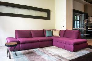 eine lila Couch im Wohnzimmer in der Unterkunft Deluxe Cosmopolitan Apartment Budapest, with Private Parking in Budapest