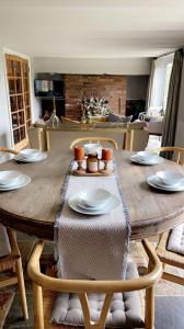 a wooden table with plates and bowls on top of it at Leo's Holiday Cottage in Doddington