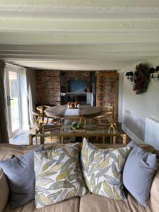 ein Wohnzimmer mit einem Sofa und einem Tisch in der Unterkunft Leo's Holiday Cottage in Doddington