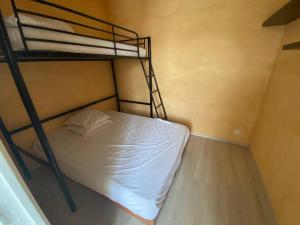 a bedroom with a bunk bed with white sheets at La maison du Coteau in Bourré