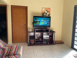 a television sitting on a stand in a living room at Rancho próximo rio pesca Sales in Sales