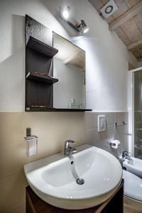 La salle de bains est pourvue d'un lavabo et d'un miroir. dans l'établissement Roommo Beccaria, à Florence