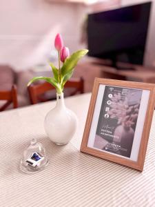 a vase with a flower in it next to a picture at Butera Apartments in Bagheria