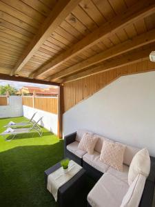 een woonkamer met een bank en een groen gazon bij Beach Villa private heated pool in Caleta De Fuste