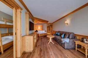 ein Wohnzimmer mit einem Sofa und einem Bett in der Unterkunft Quellenhof Luxury Resort Passeier in Sankt Martin in Passeier