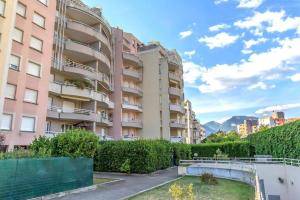a pink apartment building with a garden in front of it at Maupassant: T1bis lit 160 - clim - parking gratuit in Grenoble