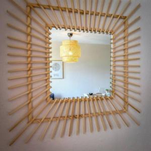 a mirror with a wooden frame on a wall at Maupassant: T1bis lit 160 - clim - parking gratuit in Grenoble