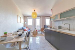 a kitchen with a table and a dining room at Maupassant: T1bis lit 160 - clim - parking gratuit in Grenoble