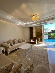 a living room with a couch and a table at Al Sawah Stand Alone Villa With Private Pool in Sheikh Zayed
